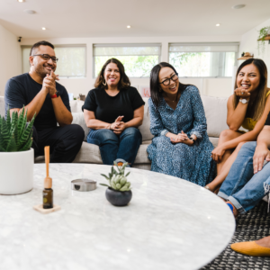 people gathered around a round coffee table smiling and laughing